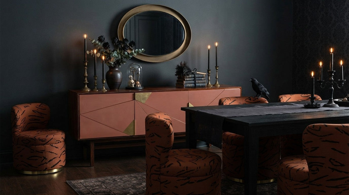 Dark candlelit dining room with a Jazz sideboard in powder lacquer and brass and Mimi swivel chairs in a graphic rust fabric