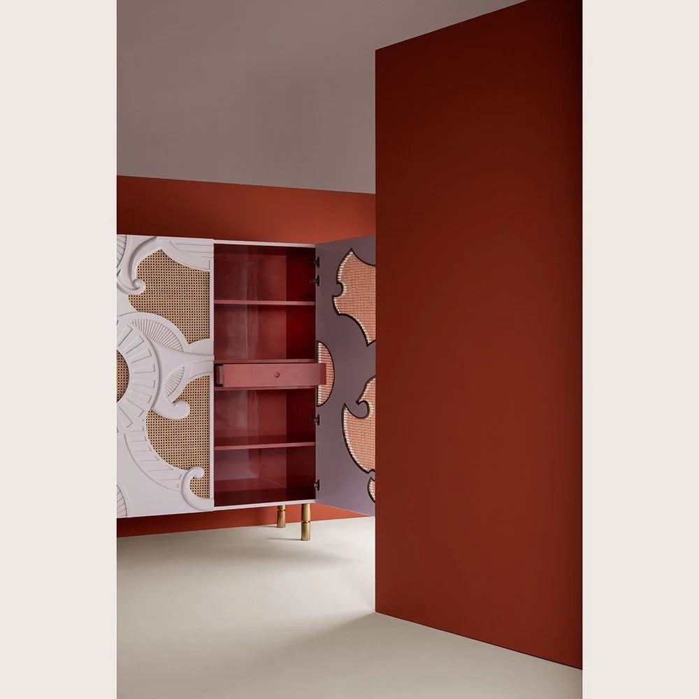 Sideboard with painted doors opening against a red wall