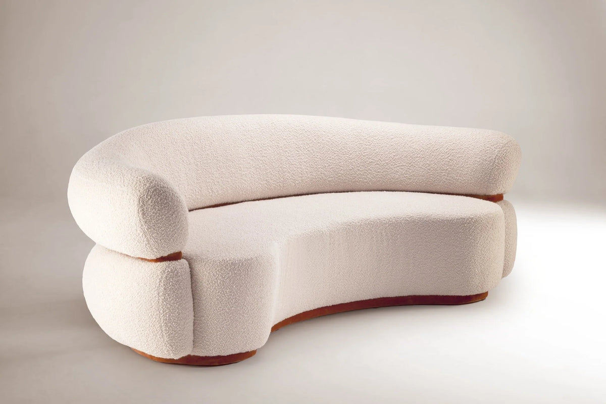 Curved cream bouclé sofa with a rounded back and slim wood base