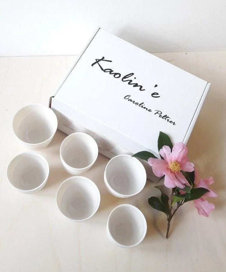 White porcelain cups in a gift box with a pink camellia