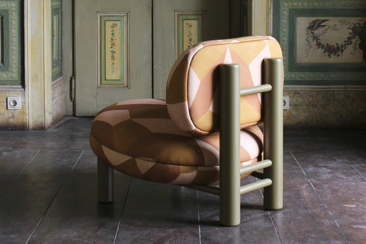 Aimi Lounge Chair in orange geometric fabric, rear view in a historic painted-panel room