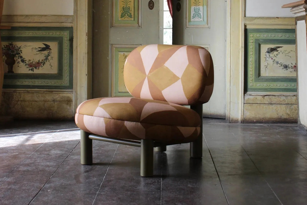 Aimi Lounge Chair in orange geometric fabric in a historic room with dark wood floors