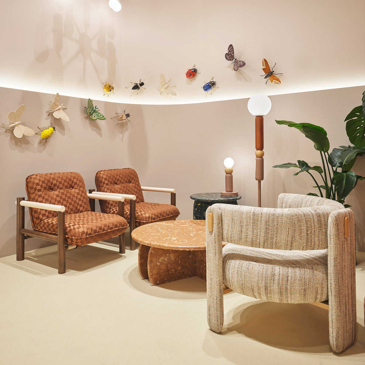 Choux Armchair in cream weave in a lounge with brown leather chairs and butterfly wall art