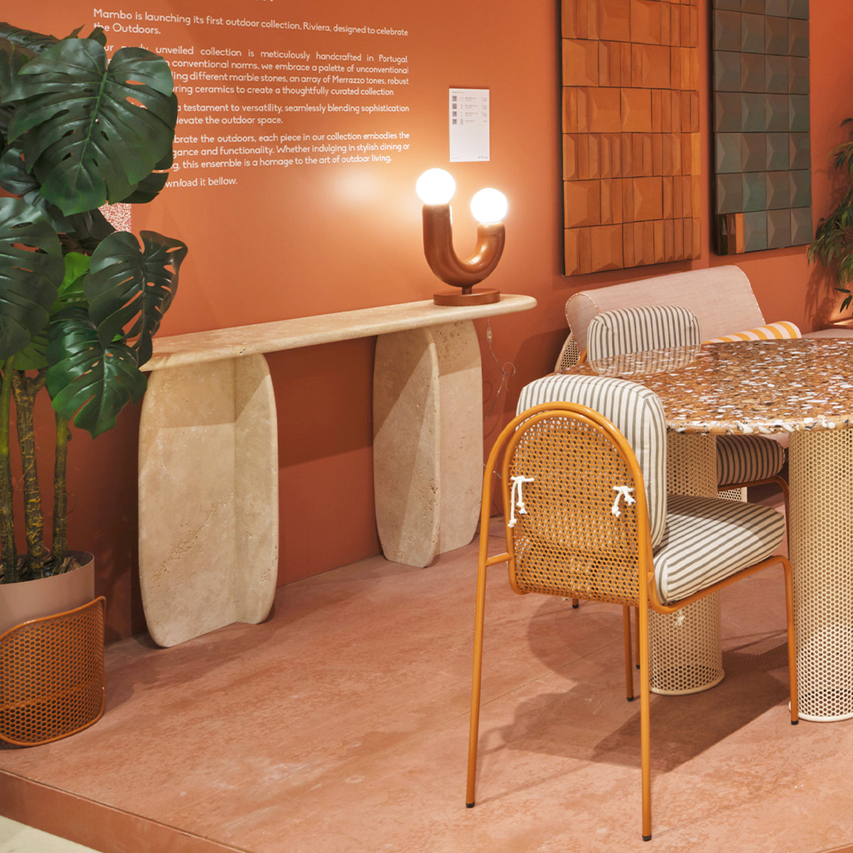 Catus Marble Console Table in Travertine against an orange wall with outdoor chairs