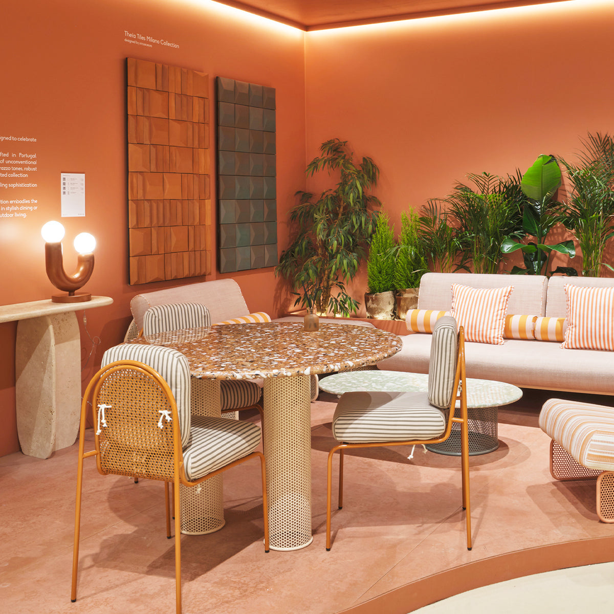 Terra Cota wall art in an orange showroom above an outdoor dining set