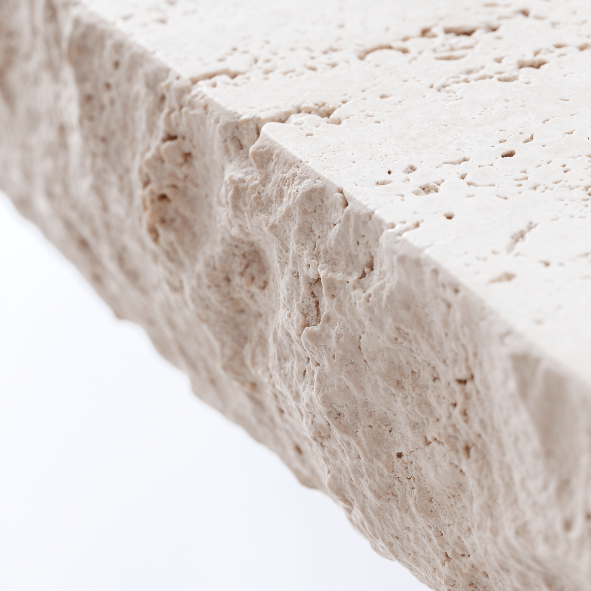 On The Rocks Side Table close-up of the rough-cut Travertine top edge