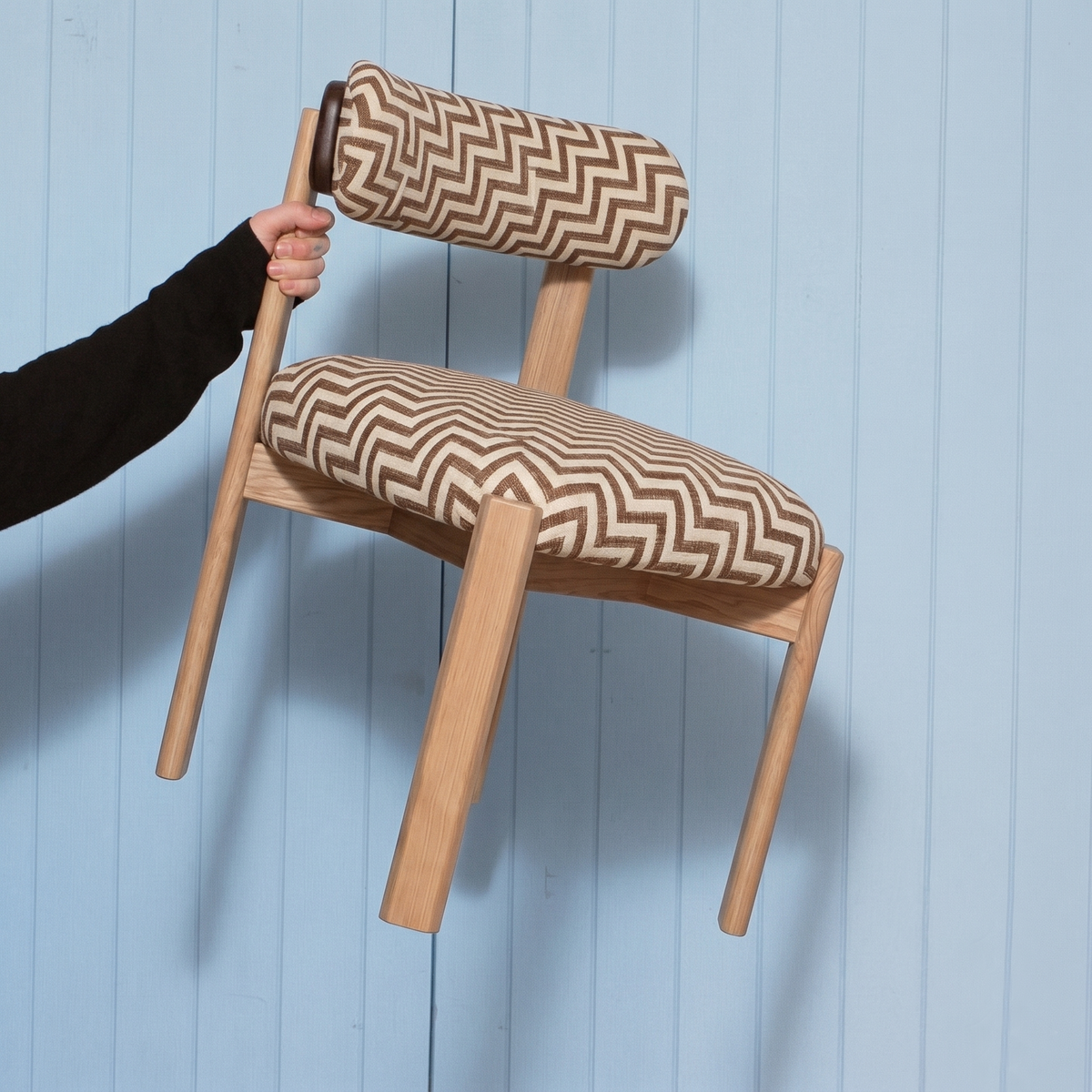 Siena Dining Chair in chevron fabric held up against a blue wall