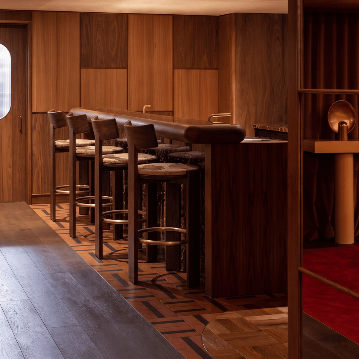 Nest Bar & Counter Stools in dark ash at a wood-panelled bar