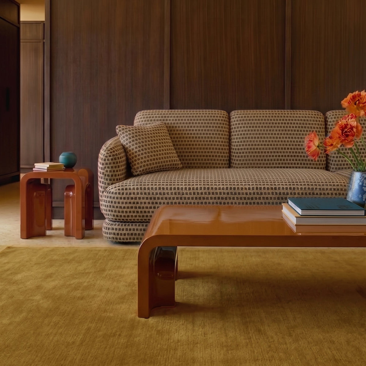 Plié Centre Table in glossy caramel lacquer in a wood-panelled living room