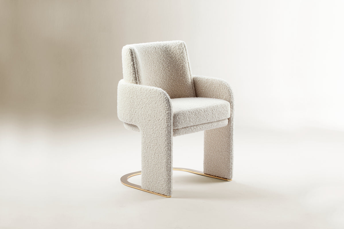 Odisseia Dining Chair in ivory bouclé, front three-quarter view on a studio backdrop