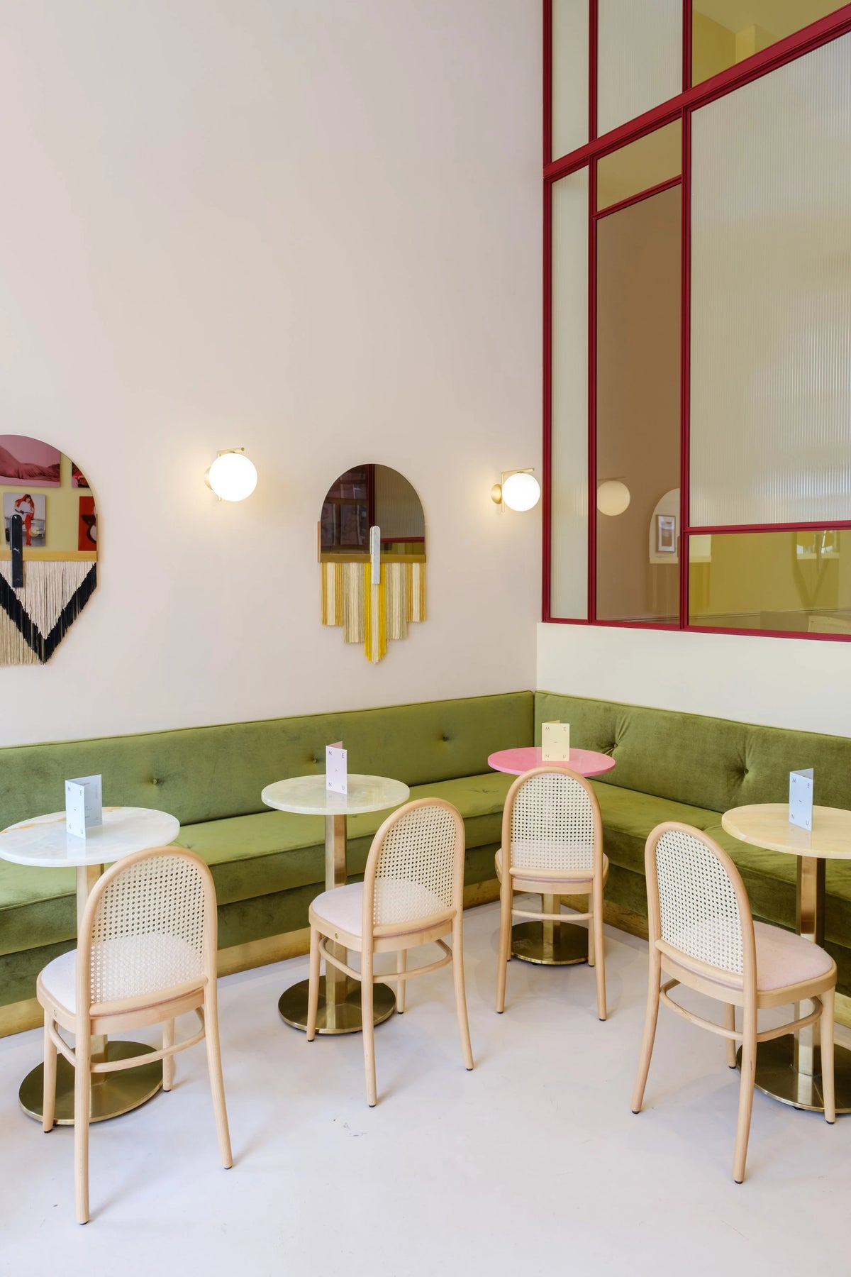 Souk Mirror Black in a café with cane chairs and green banquette