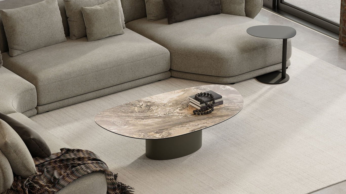 Argon Coffee Table with dark marble top in front of a grey sofa, angled from above