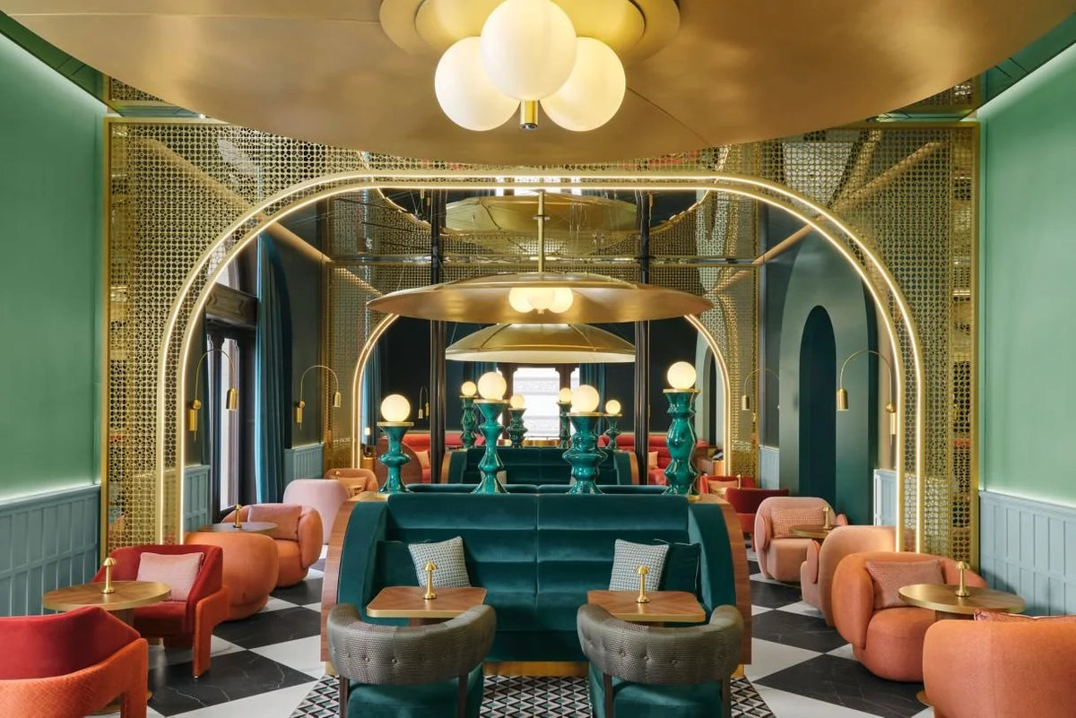 L’Unité Chair in orange velvet in a green and brass lounge interior