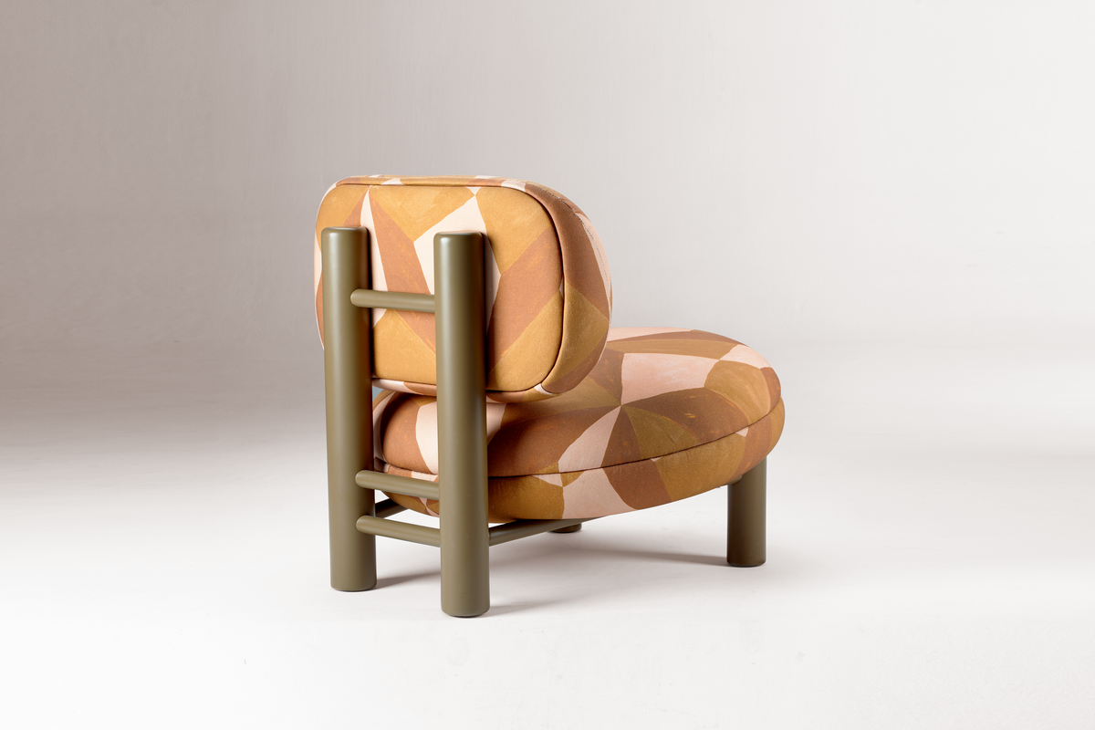Aimi Lounge Chair in orange geometric fabric, rear three-quarter view on grey