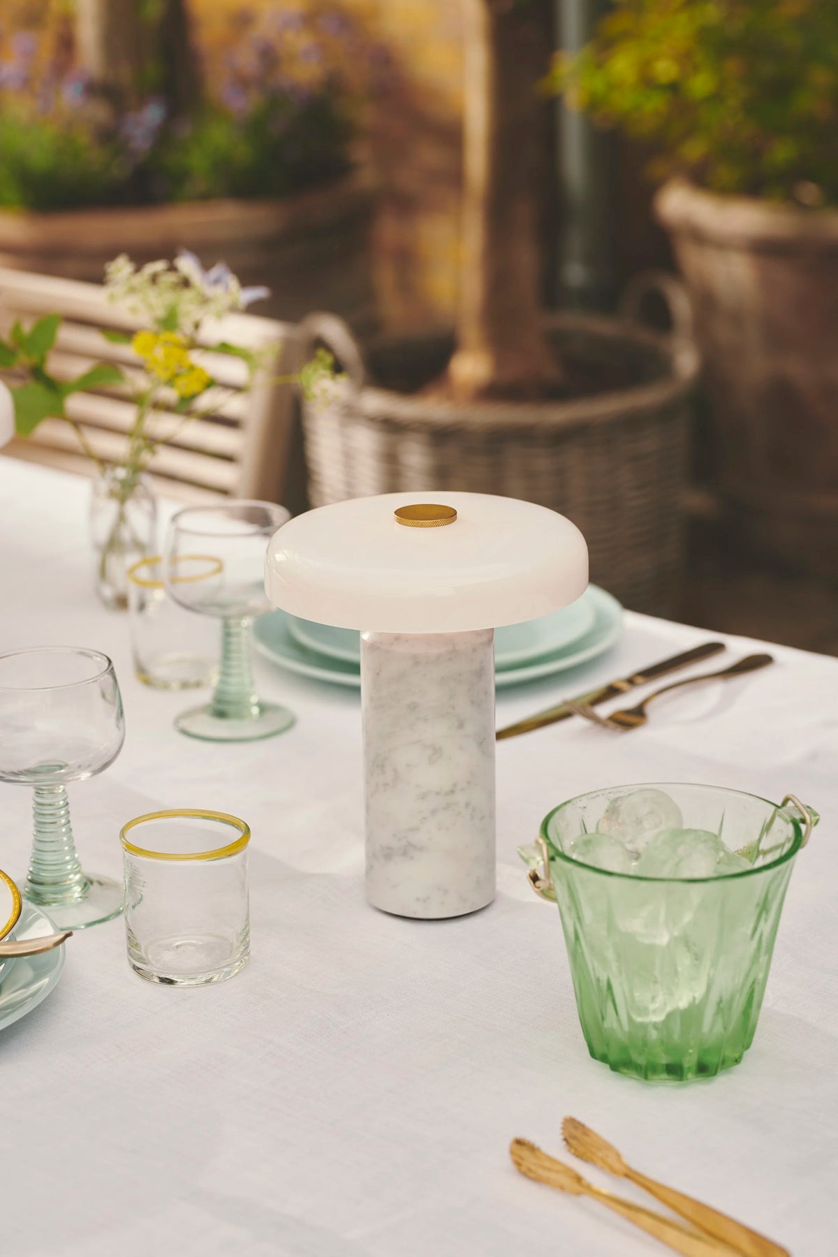 Trip Table Lamp in Carrara / Opal on a set garden table with green glassware