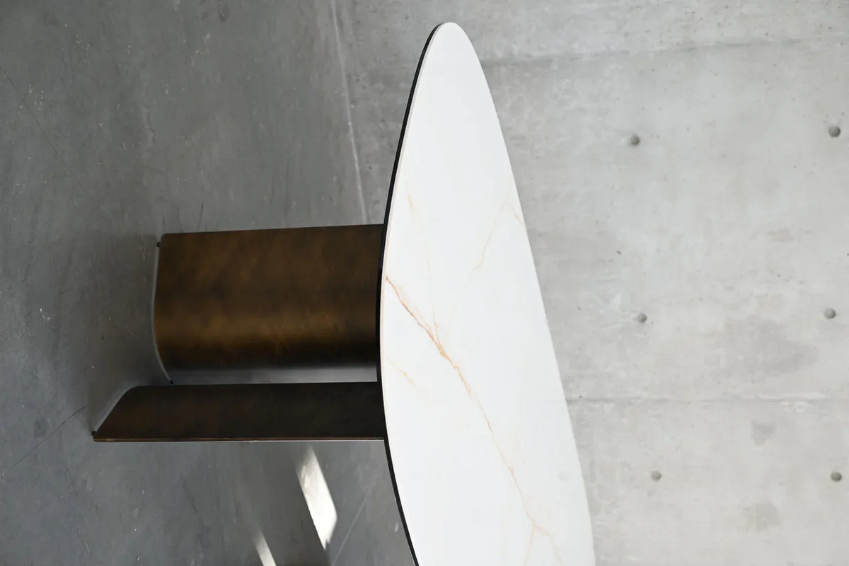 Sorrento Dining Table detail of curved bronze leg beneath the tabletop