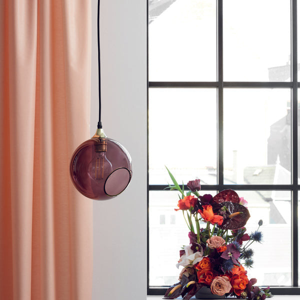 Ballroom Purple Rain Pendant Light hanging by a peach curtain and window with red flowers