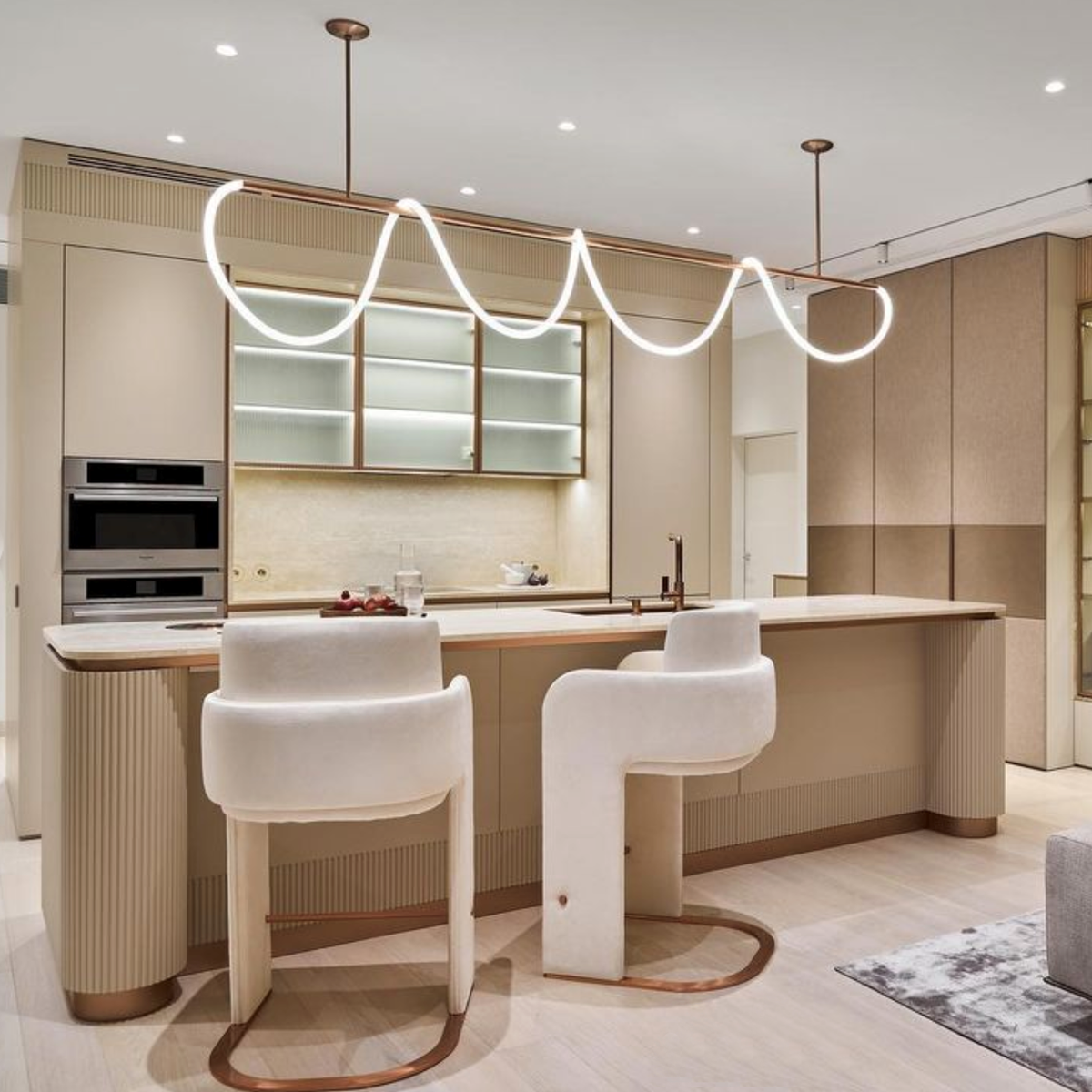 Odisseia Bar Stool pair in ivory bouclé at a kitchen island with a looped pendant light