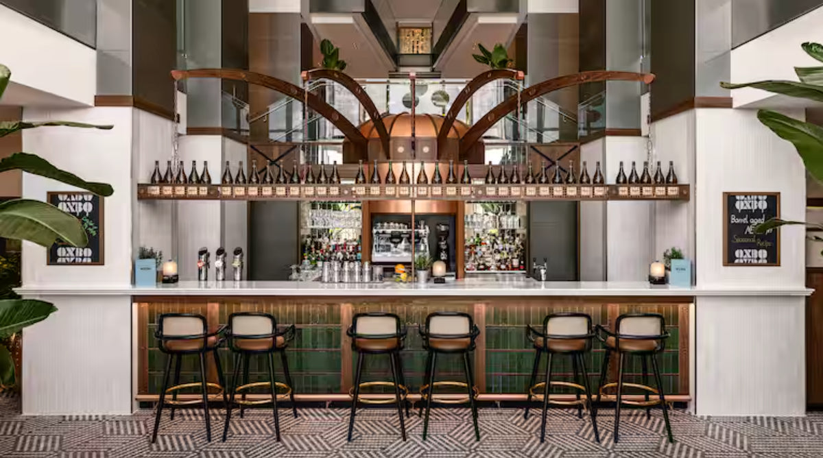 Row of Luc bar chairs at a hotel bar with a white tiled counter