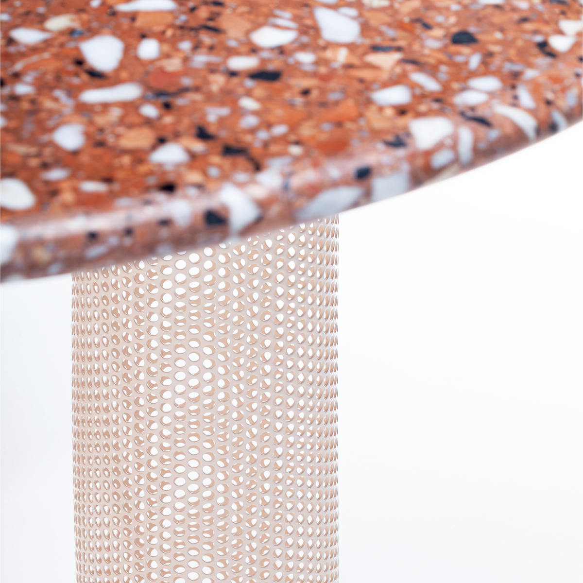 Riviera Dining Table close-up of Terrazzo Red top edge over perforated base