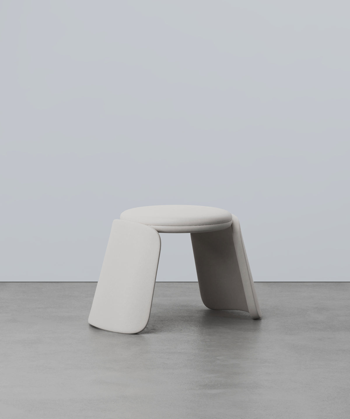 Inge Pouf in light grey on a concrete floor, front view
