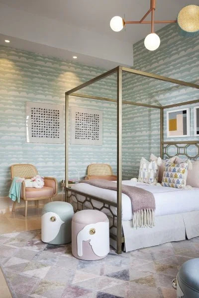 Luc Armchair in blush fabric in a bedroom with a brass canopy bed