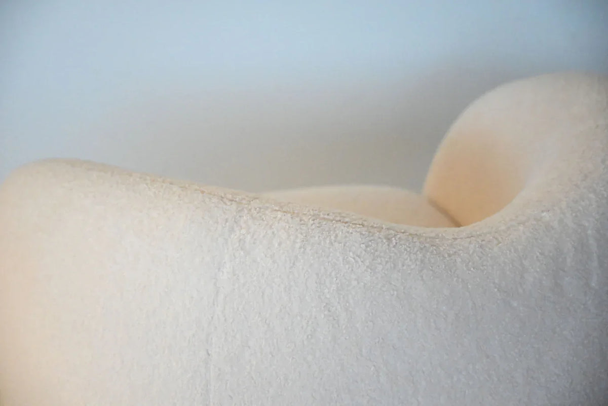 Dune Swivel Lounge Chair in Cream Teddy, soft-focus detail of the rounded backrest