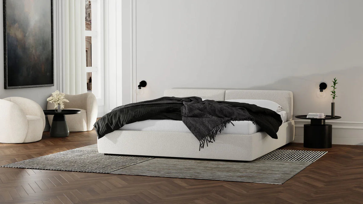 Dune Swivel Lounge Chair in Cream Teddy in a bedroom beside a white bed
