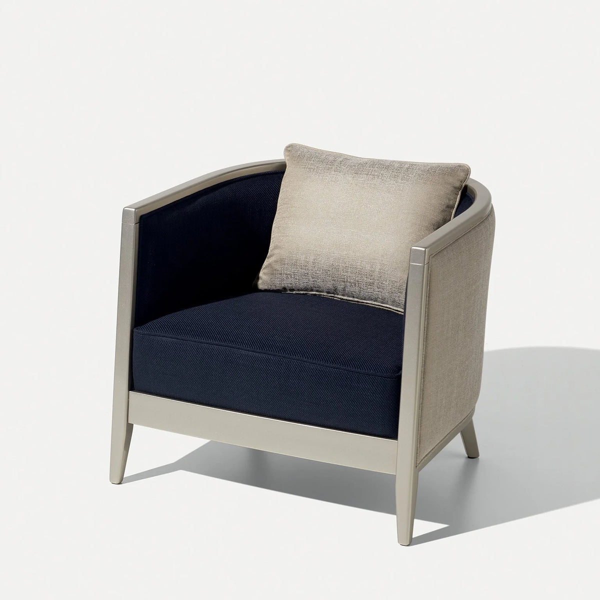 Saten Armchair in navy with ivory frame and a cream cushion, three-quarter view