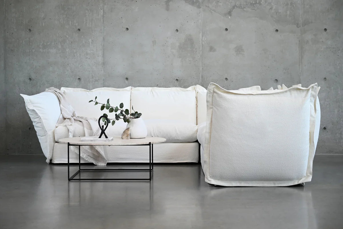 Willow Sectional Sofa in white against a concrete wall with a coffee table