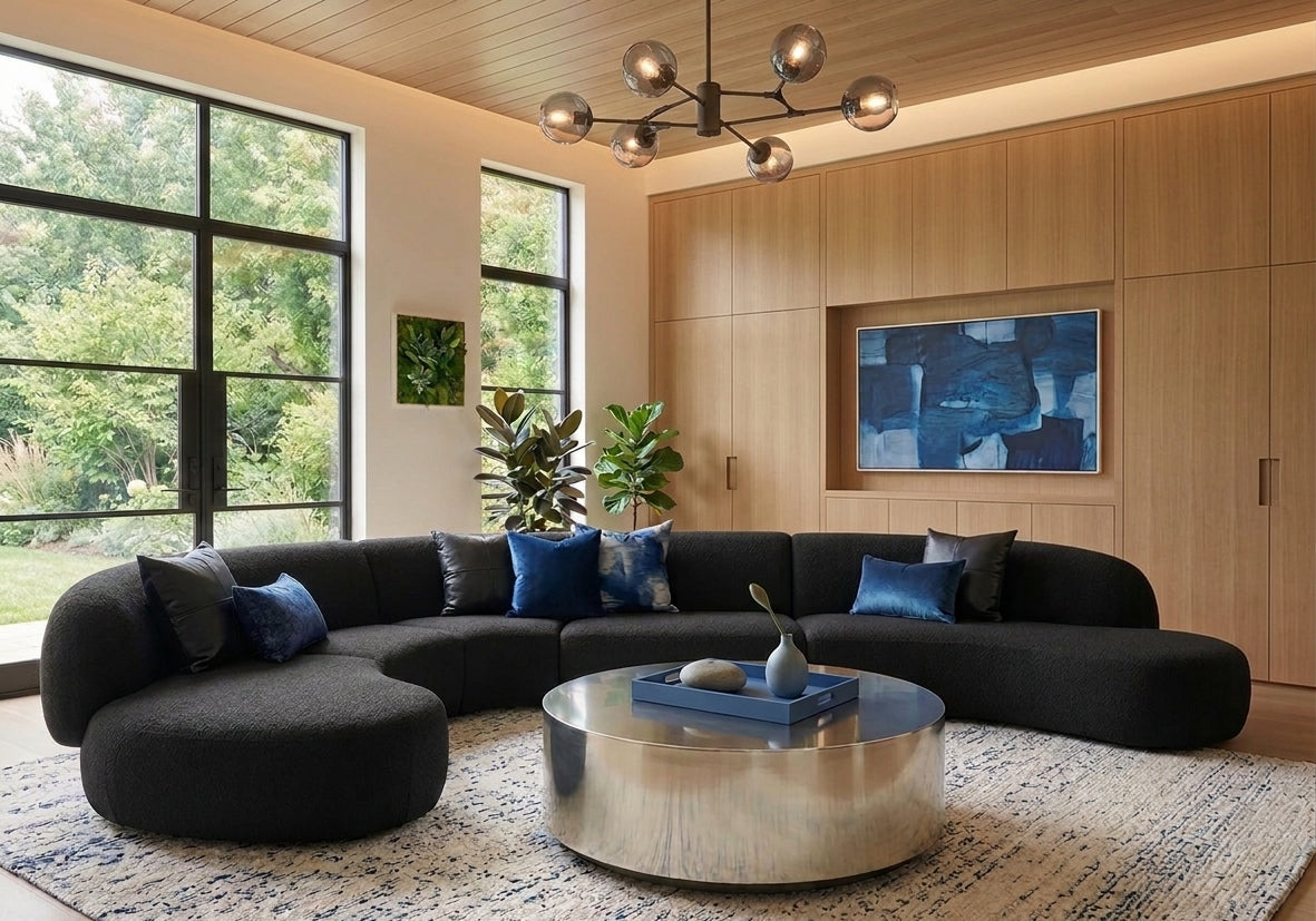 Sphere Coffee Table in Steel Polished with a curved black sofa in a wood-panelled room
