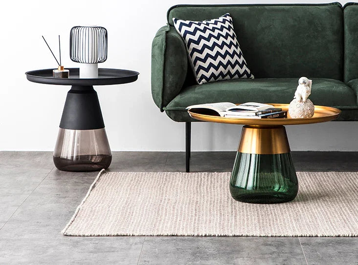 Duverre Side Table in black and brass finishes beside a green velvet sofa