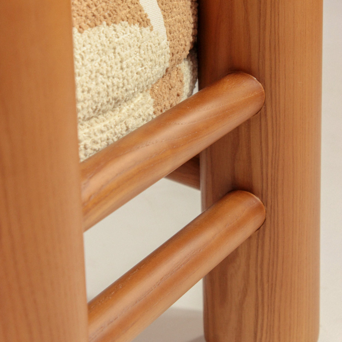 Aimi Lounge Chair, close-up of the warm wood ladder-back rails