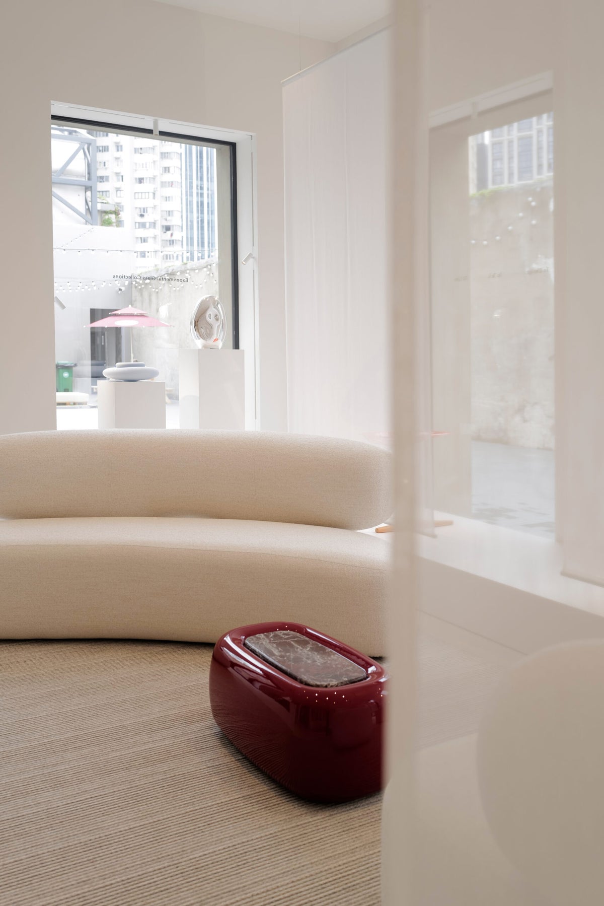 Asawa Sofa curved along a window wall with a red lacquer table