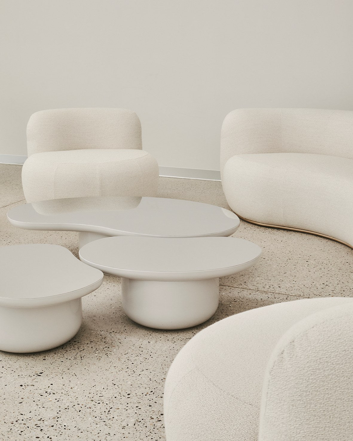 B-15 Z Lounge Chairs in ivory bouclé around white organic low tables on a terrazzo floor
