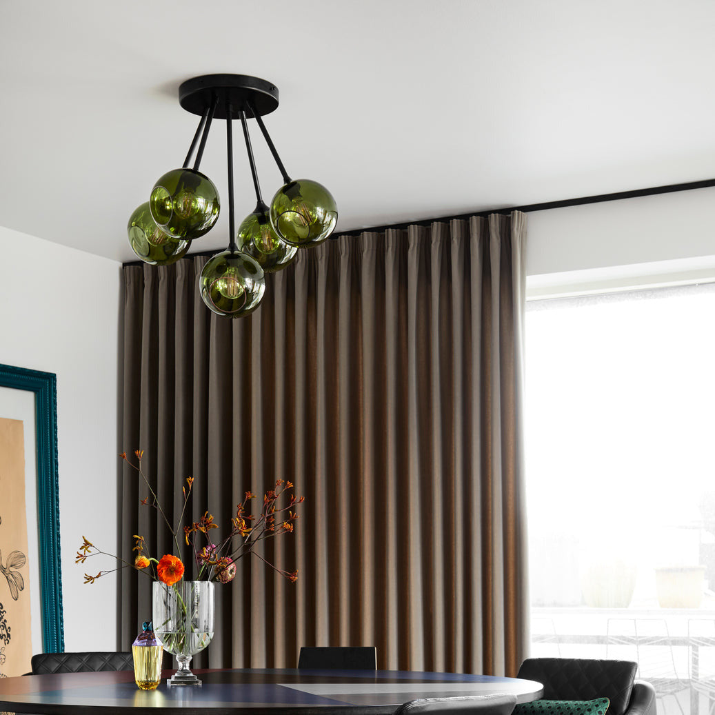 Ballroom Molecule Chandelier with smoky green glass and black frame above a dining table