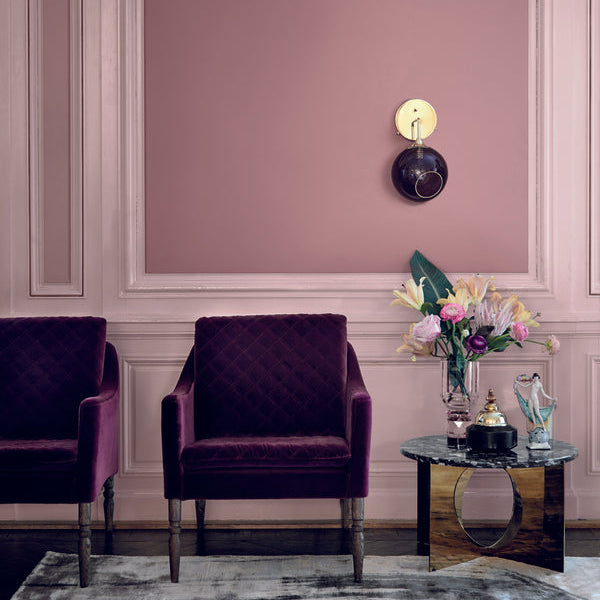 Ballroom Wall Light Sconce Purple on a pink panelled wall above purple velvet armchairs