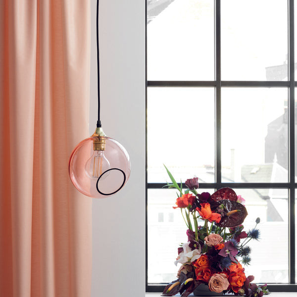 Ballroom Pendant Light in pink glass with gold fitting by a window and floral arrangement