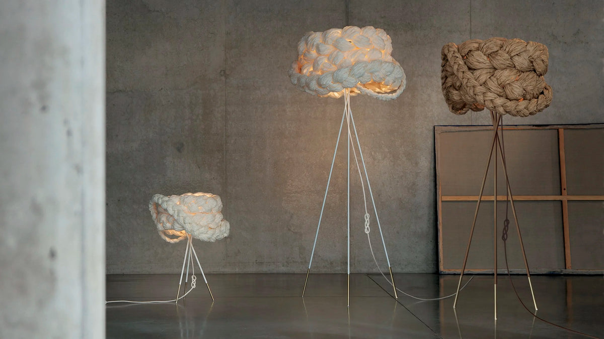 Mammalampa Bride floor and table lamps glowing in white and brown against a concrete wall