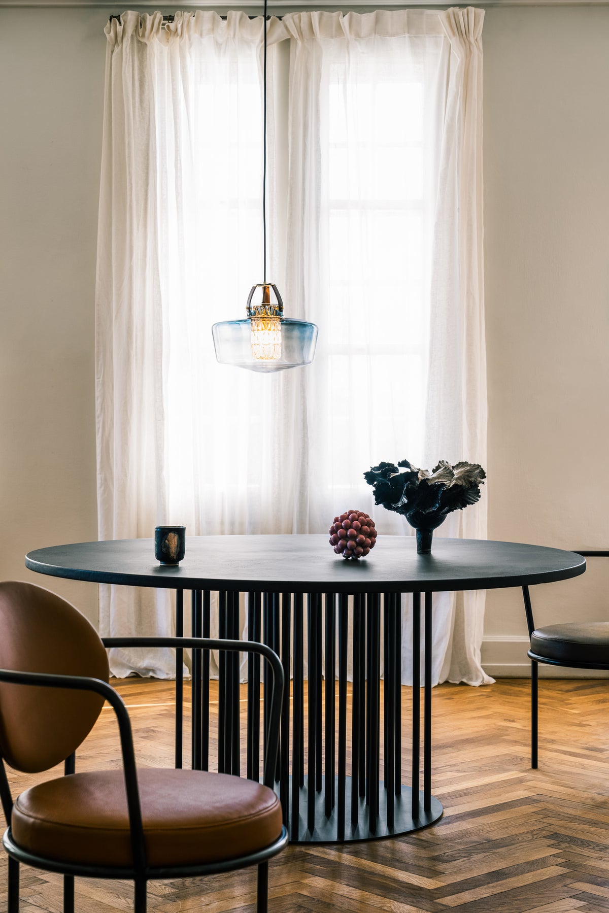 Casablanca Chair in Cognac Leather at a round dining table under a glass pendant by a window