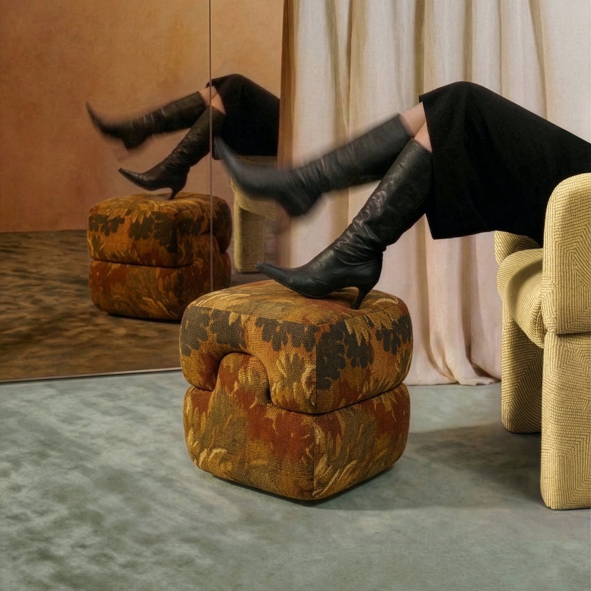 Mosaico Pouf in rust floral velvet used as a footrest beside a yellow armchair