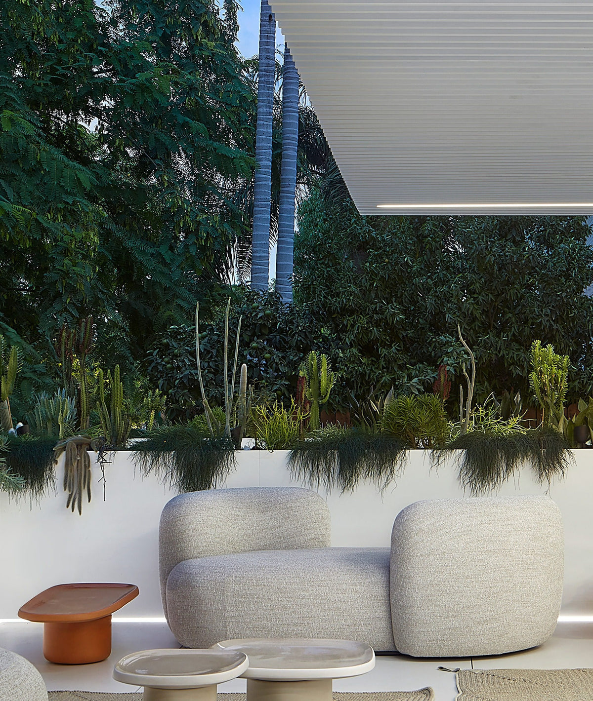 Chapter Two Sofa in grey bouclé on a garden terrace with terracotta side table