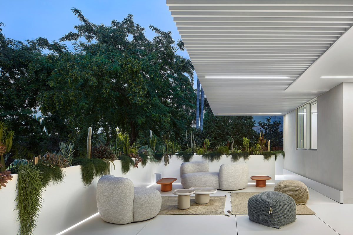 Chapter Two Sofas in grey on an evening terrace with planters and poufs