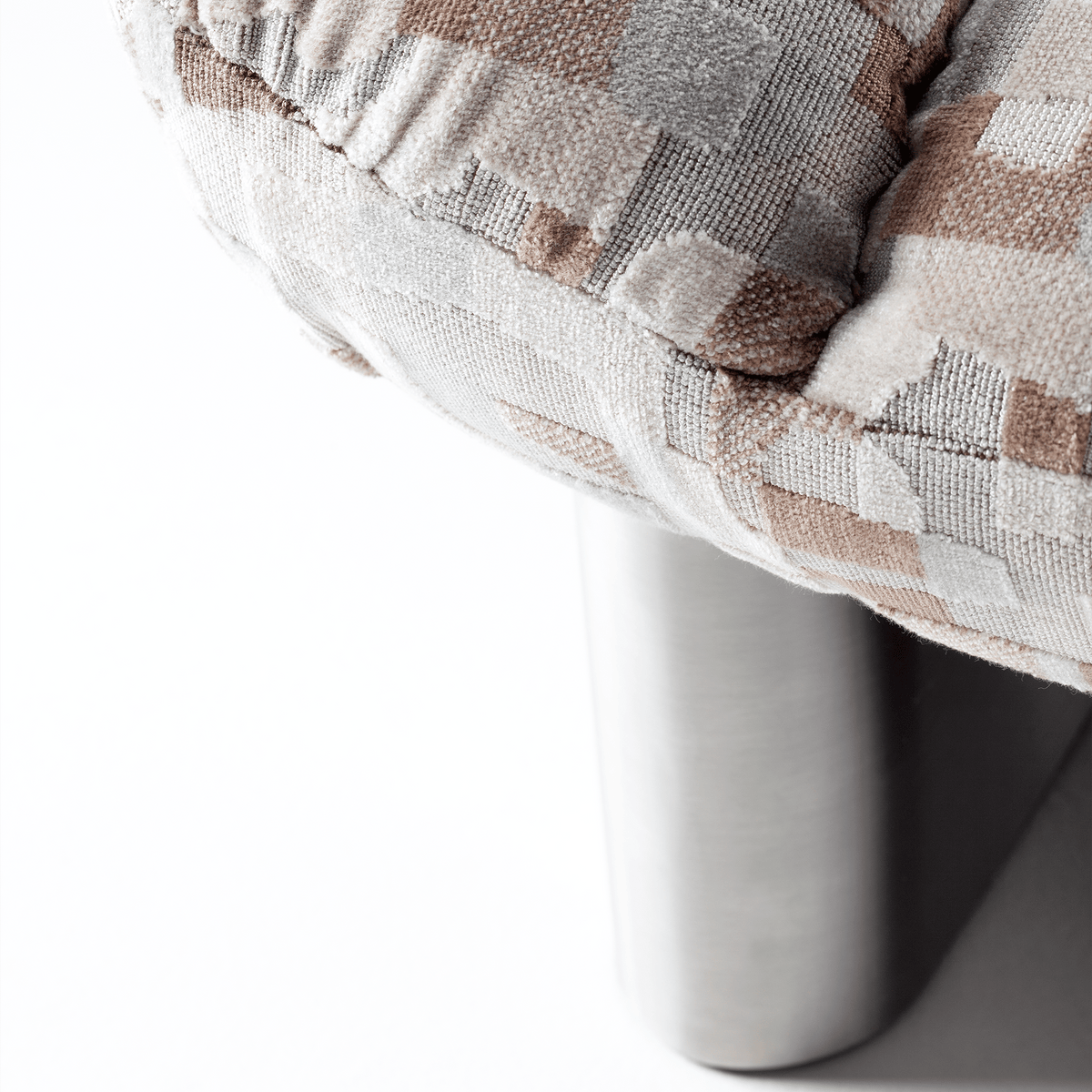 Colin Armchair close-up of patterned upholstery and polished metal leg