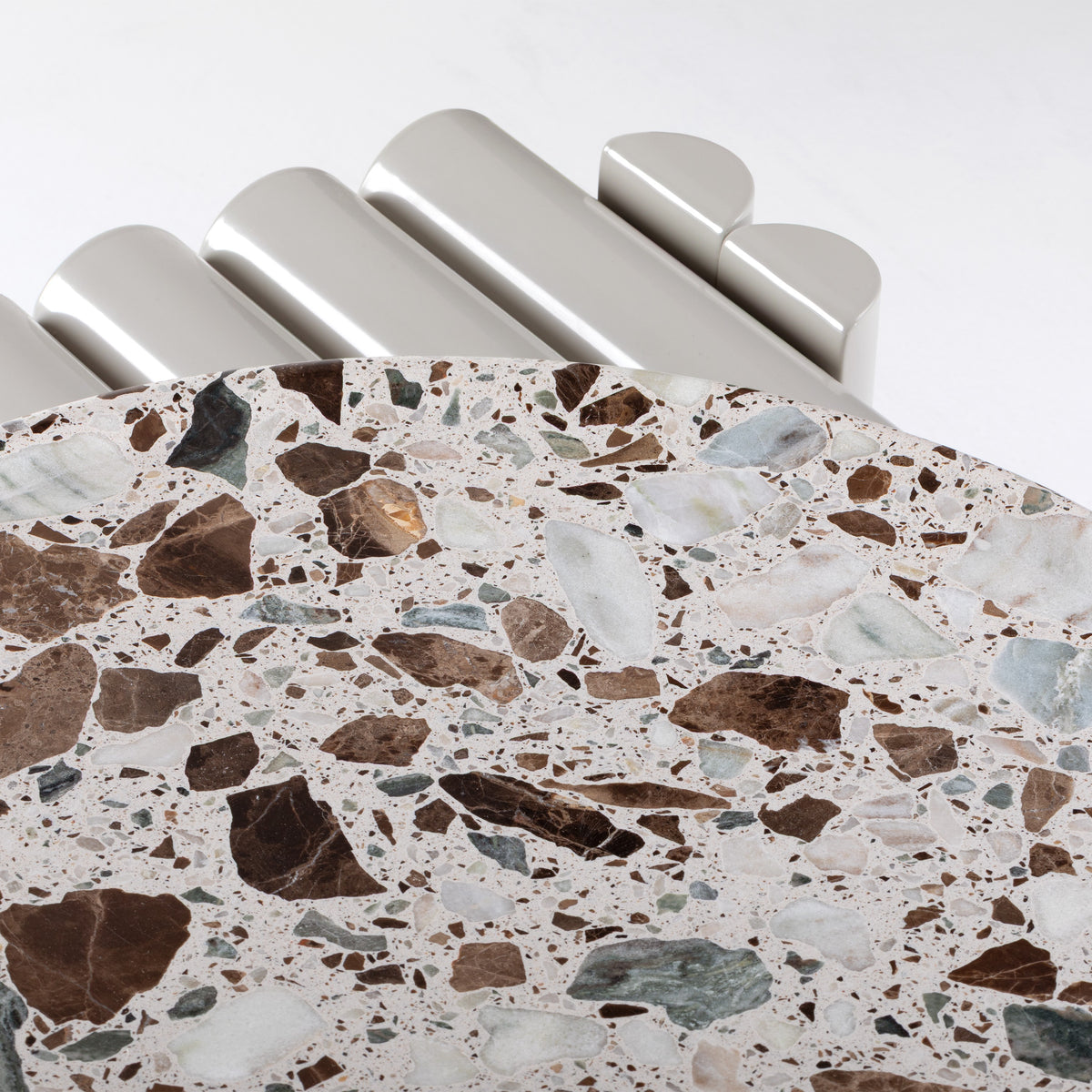 Duna Outdoor Centre Table close-up of terrazzo top beside the tubular frame