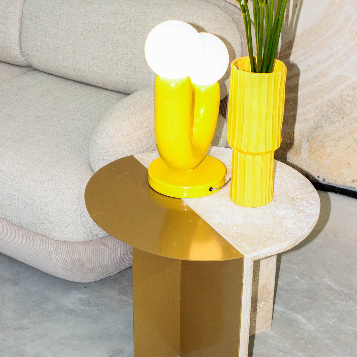 Duplex Side Table with yellow lamp and vase beside a cream sofa