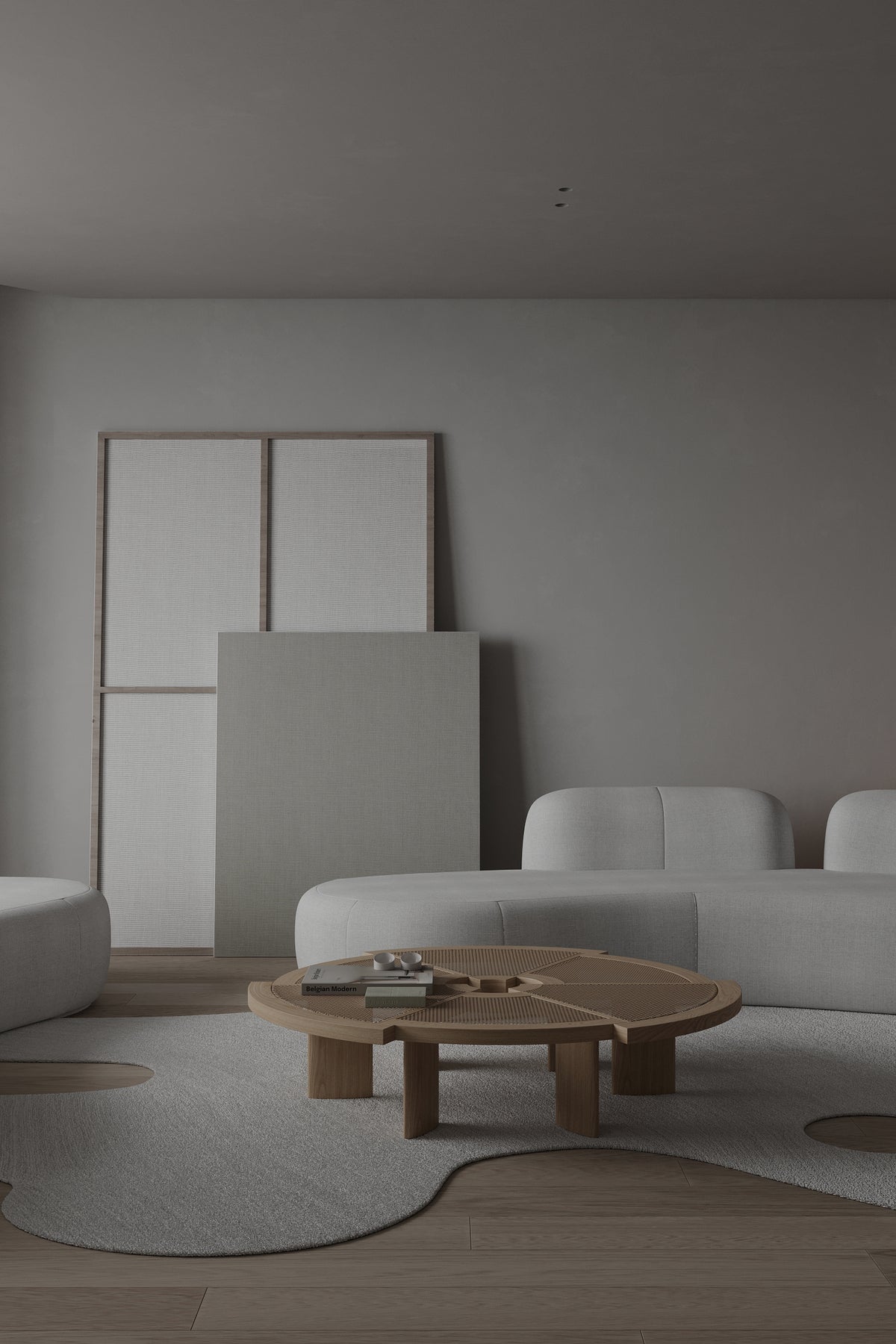 Tateyama XL Sofa in white boucle with a wood coffee table against leaning canvases