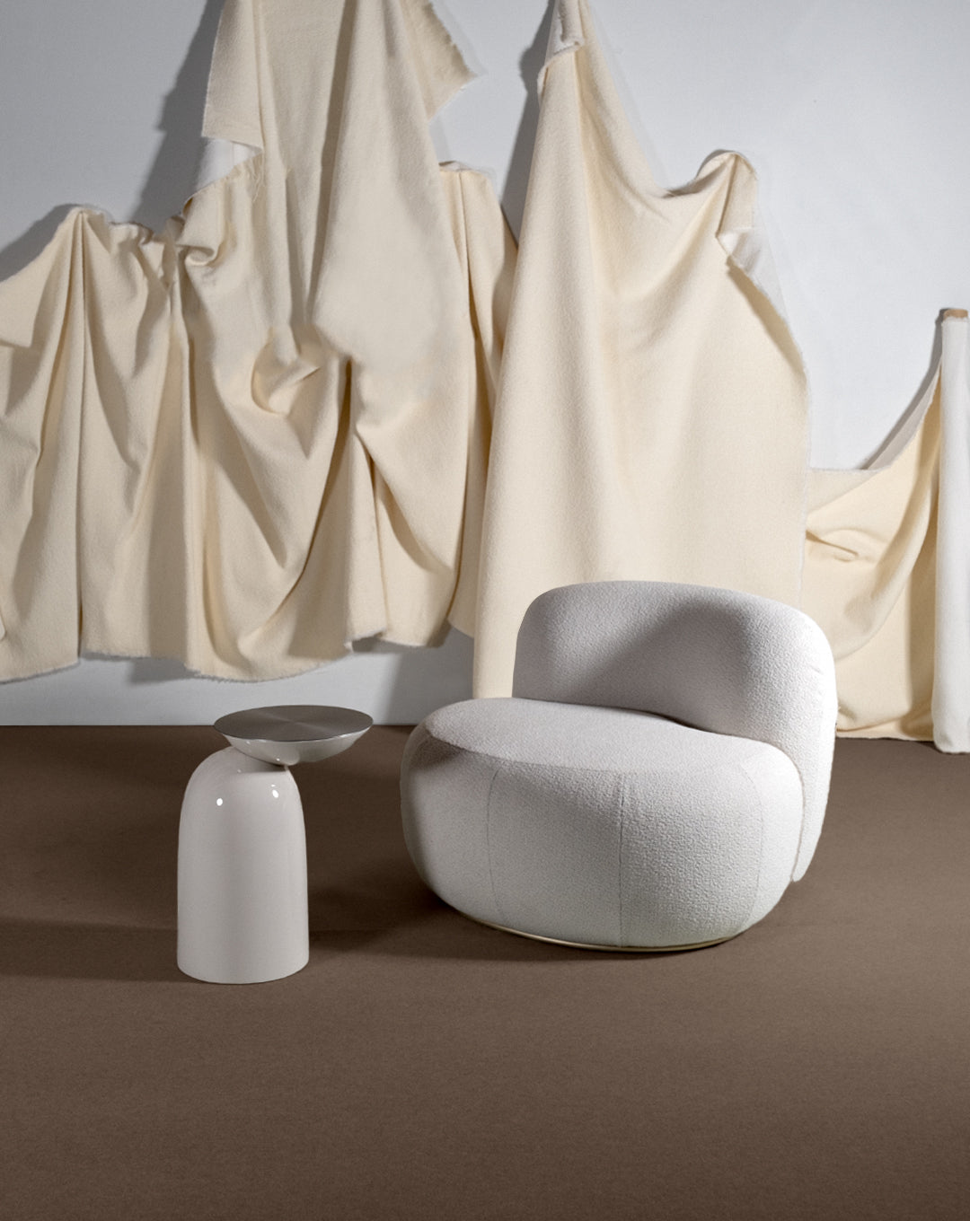 B-15 Z Lounge Chair in pale grey bouclé with a round side table and draped cream fabric