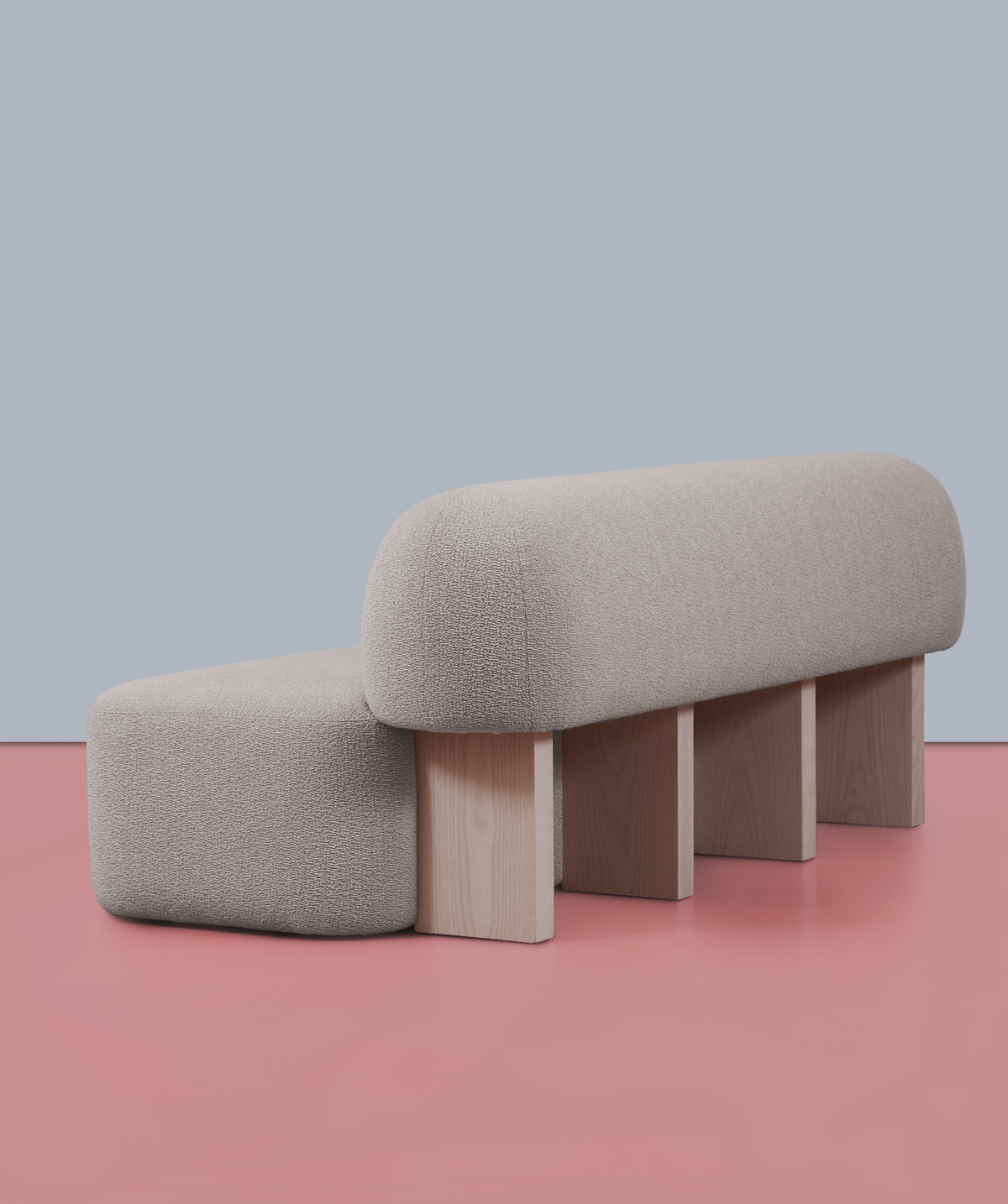 Yemeni Sofa in grey Soft Bouclé on a pale wood base against blue and pink, side view