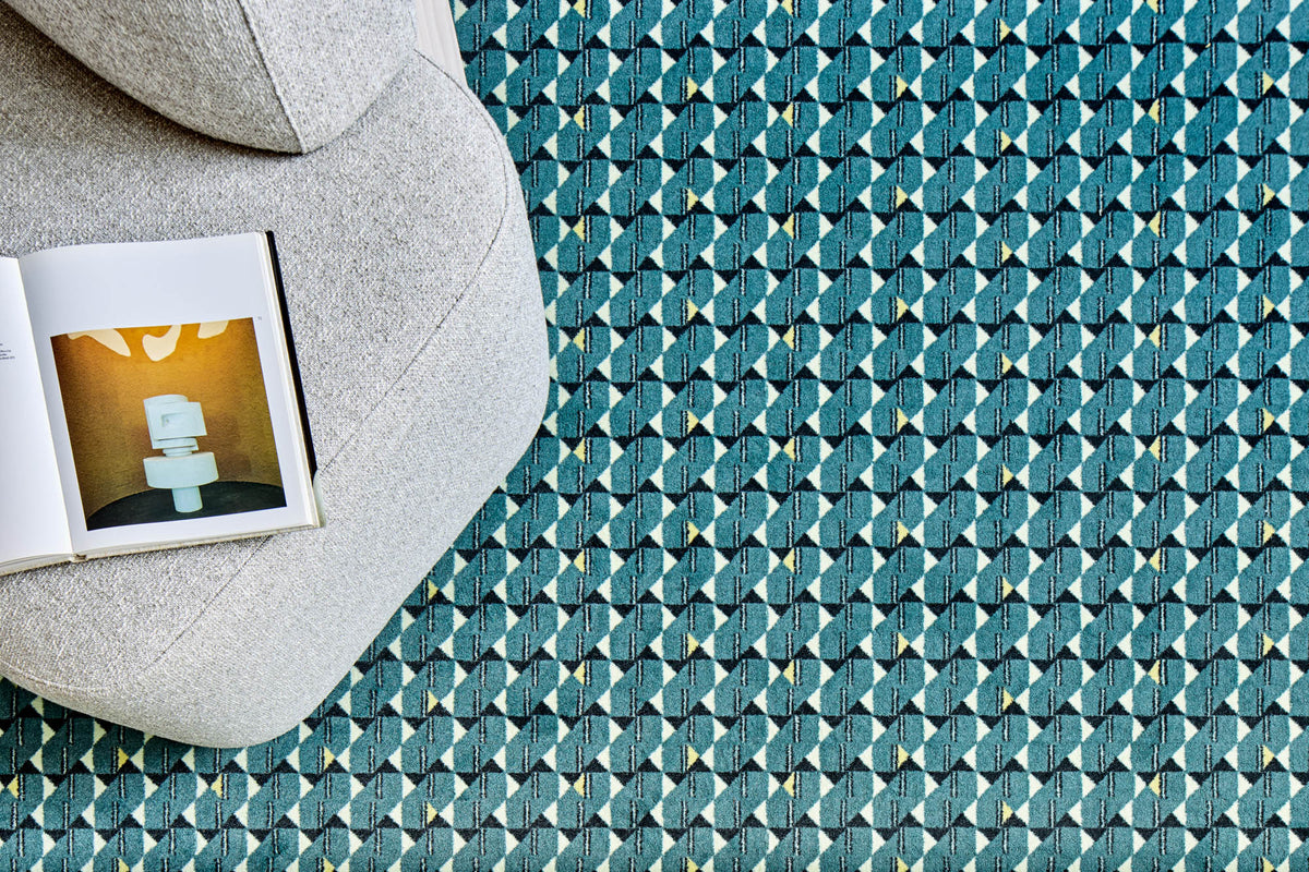 Yoshida Lounge Chair in light grey weave, top view with an open book on a teal patterned rug